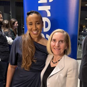 Dr. Burroughs-Ray and Dr. Finkel pose in front of a chamber pop-up banner.